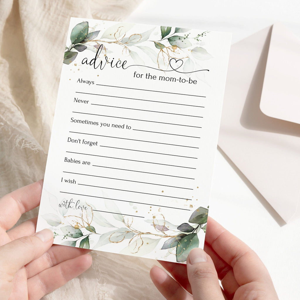 A pair of hands holding a baby shower advice card with a floral design and space for writing, with a white envelope in the background.