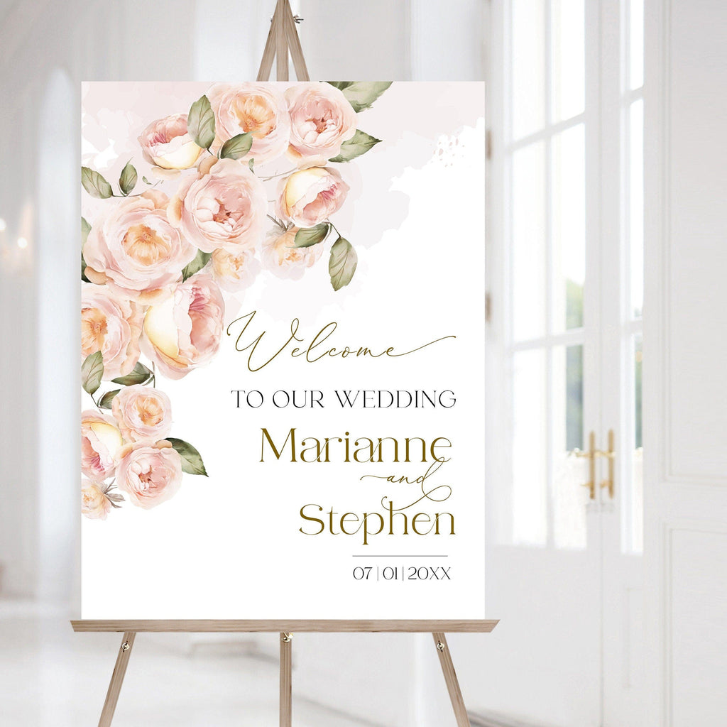 A wedding welcome sign with peach fuzz gold and apricot flowers, personalized with the names of the couple and displayed in a room with elegant decor.