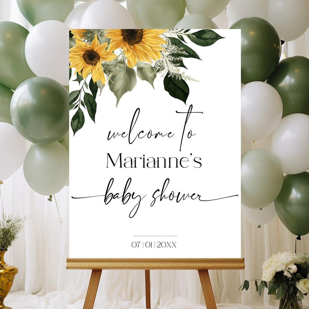 A digital image showing a baby shower welcome sign with sunflower design, displayed on a wooden easel with balloons in the background.