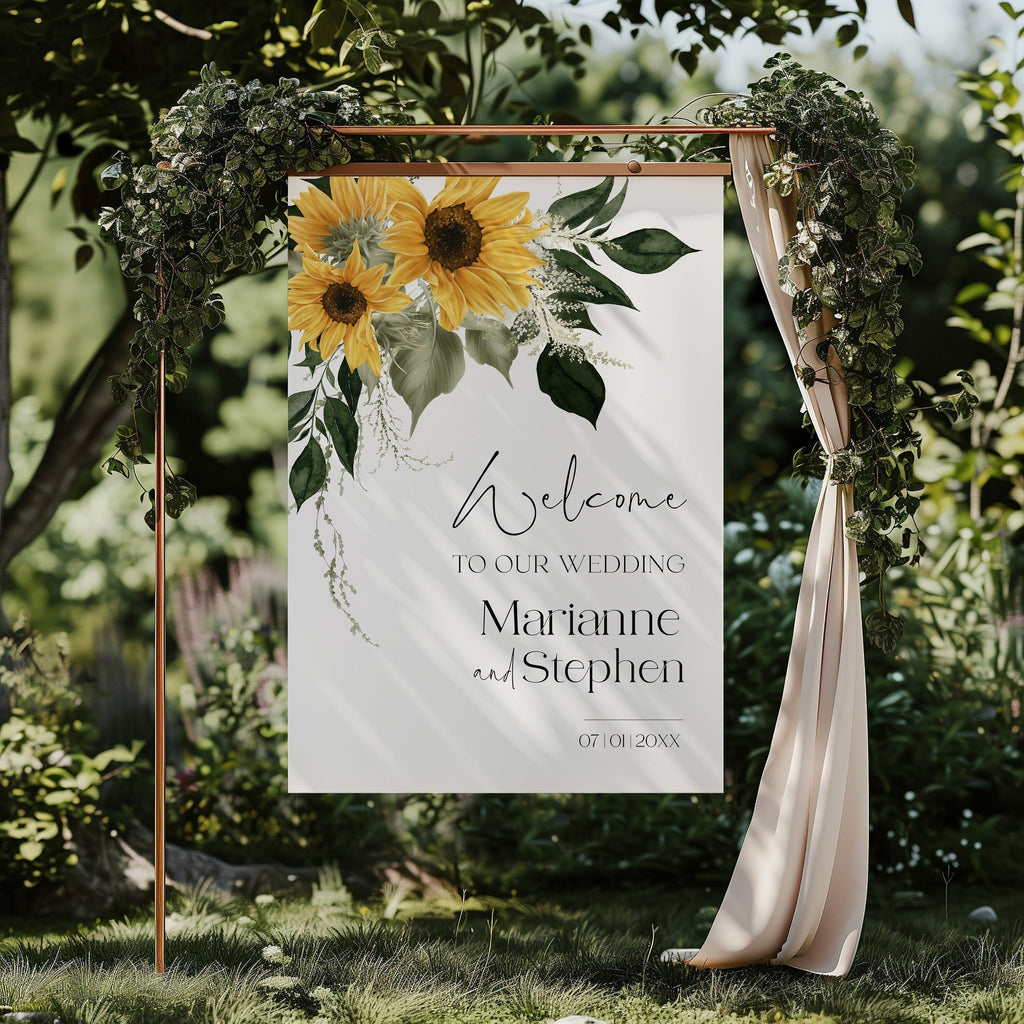 A rustic style wedding welcome sign with sunflower designs and the text 'Welcome to our wedding' displayed on a wooden board with green leaves in the background.