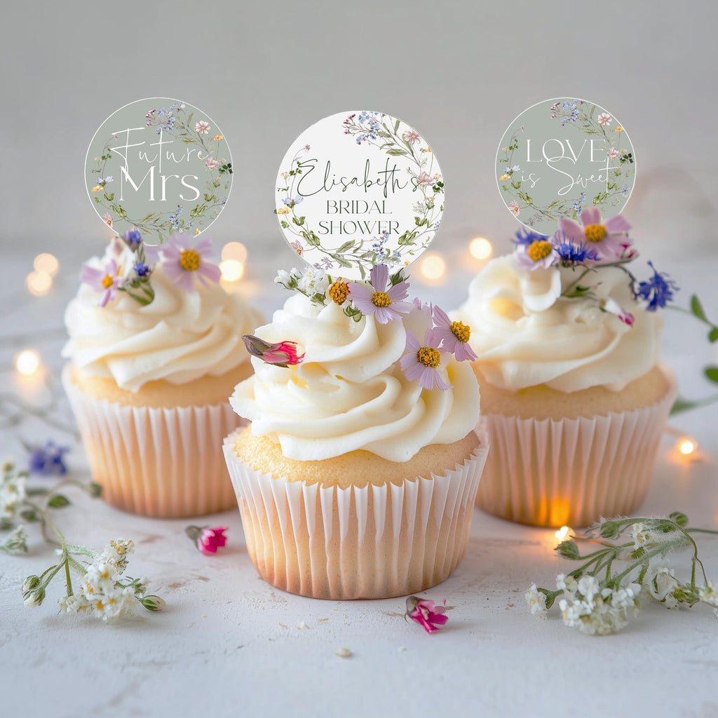 Cupcake toppers with floral designs and text placeholders 'FUTURE MRS' and 'ELISABETH' on top of cupcakes, surrounded by scattered flowers.