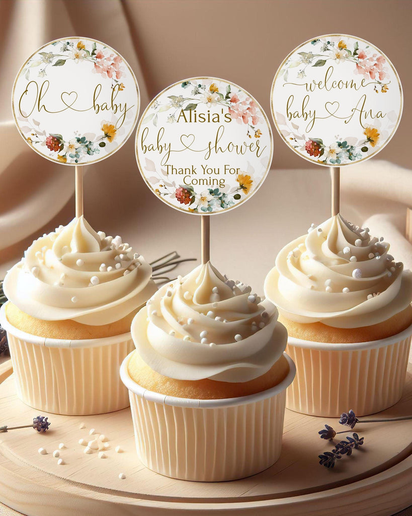 Cupcake toppers with floral patterns and baby-themed decorations, intended for a baby shower event.